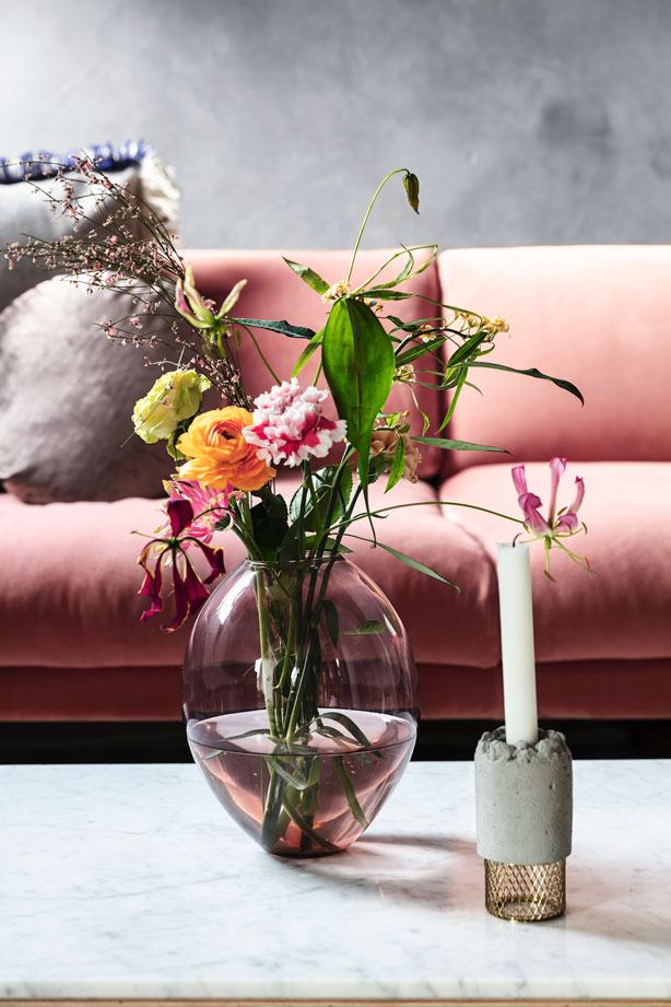 Lysestagen på sofabordet er fra NewWorks, og glasvasen med friske blomster er fra Stilleben.
