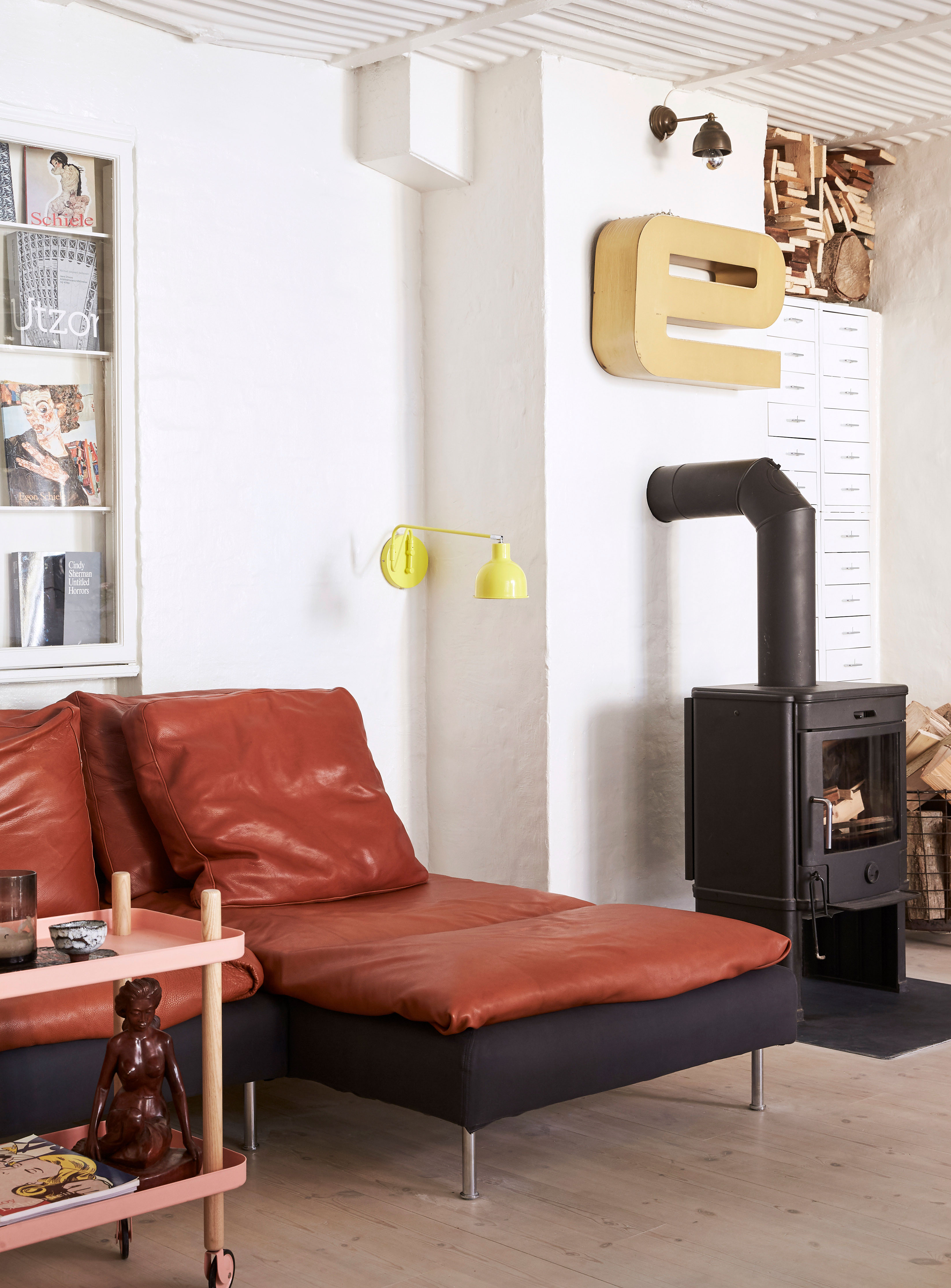 En brændeovn skaber hygge i de lange vintermåneder. For at udnytte pladsen optimalt, er der bygget en brændestabel oven på arkivskuffer fra Ikea.