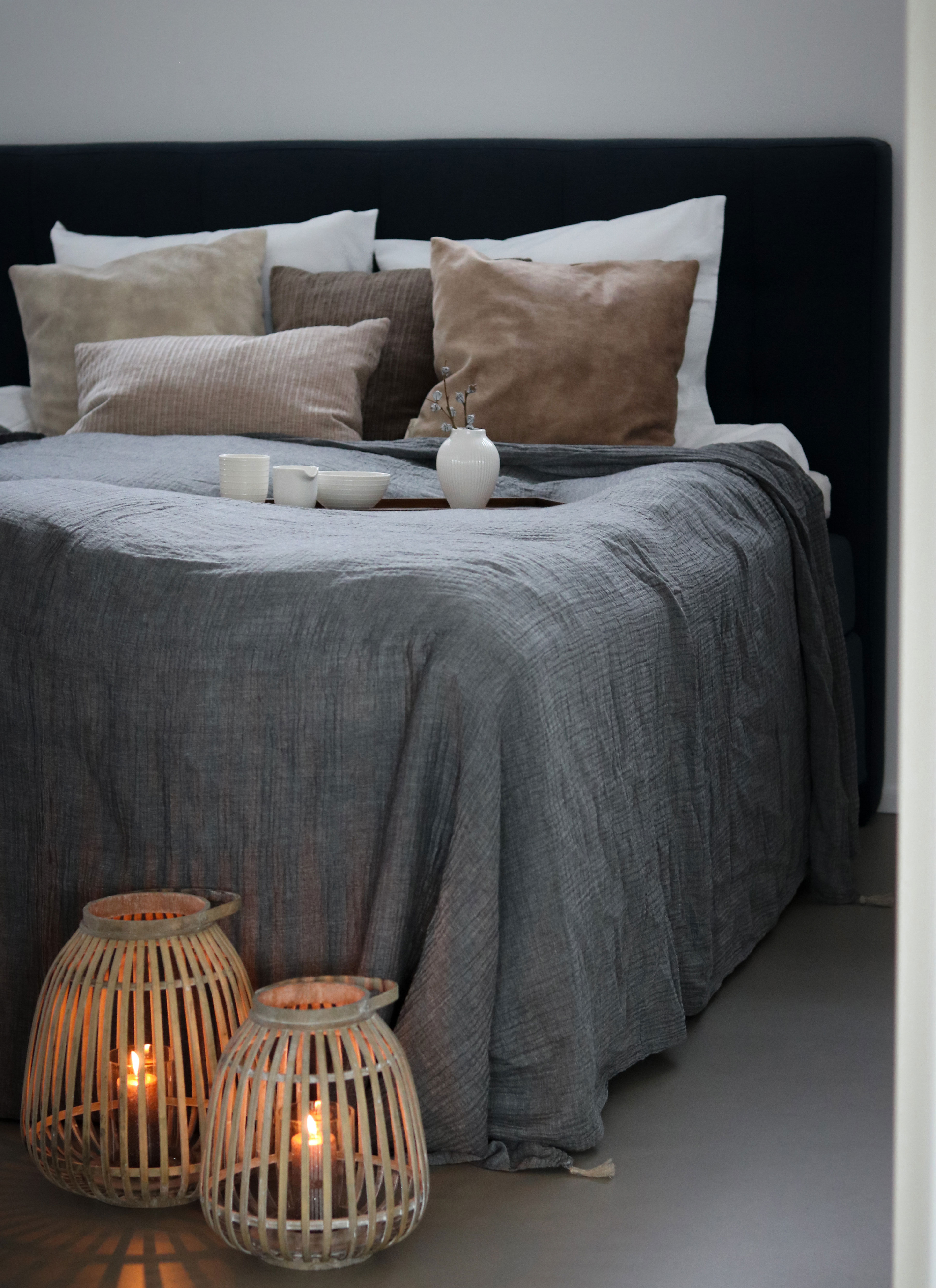 Sengetæppe fra Södahl, lanterner fra Villa Collection, puder fra Wacore og keramik fra Mia Maya Design & Knabstrup Keramik og