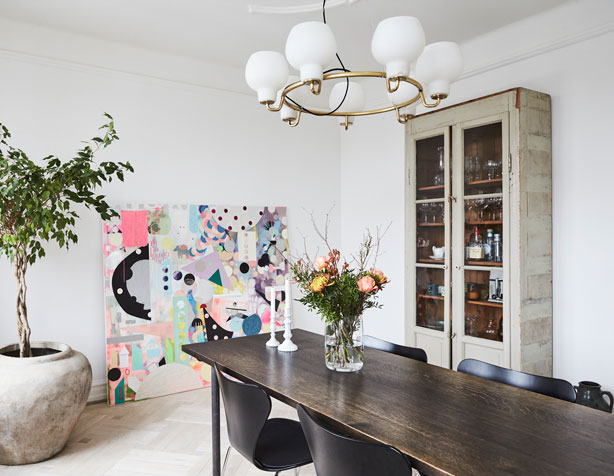 Moderne kunst mødes med klassiske arvestykker, rustikke vintagefund og eget design i spisestuen.