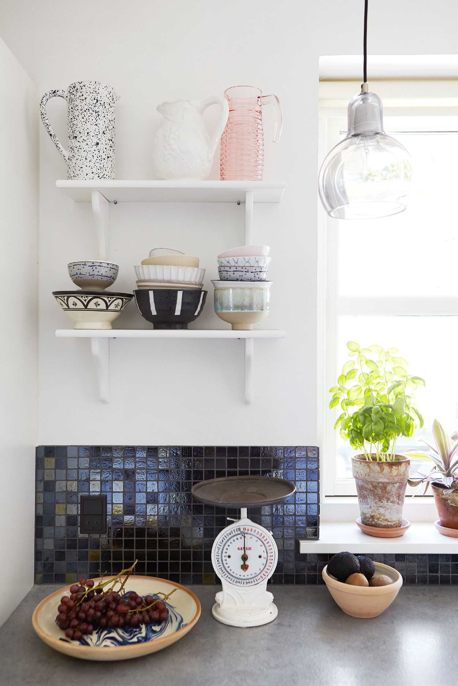 Det lyse køkken har fået kontrast med glimtende mosaiksten fra Flisekompagniet. Det fine køkkeninteriør er bl.a. fra Studio Arhøj, Søstrene Grene, H&M Home og Fabrek, mens der også er enkelte loppefund iblandt.