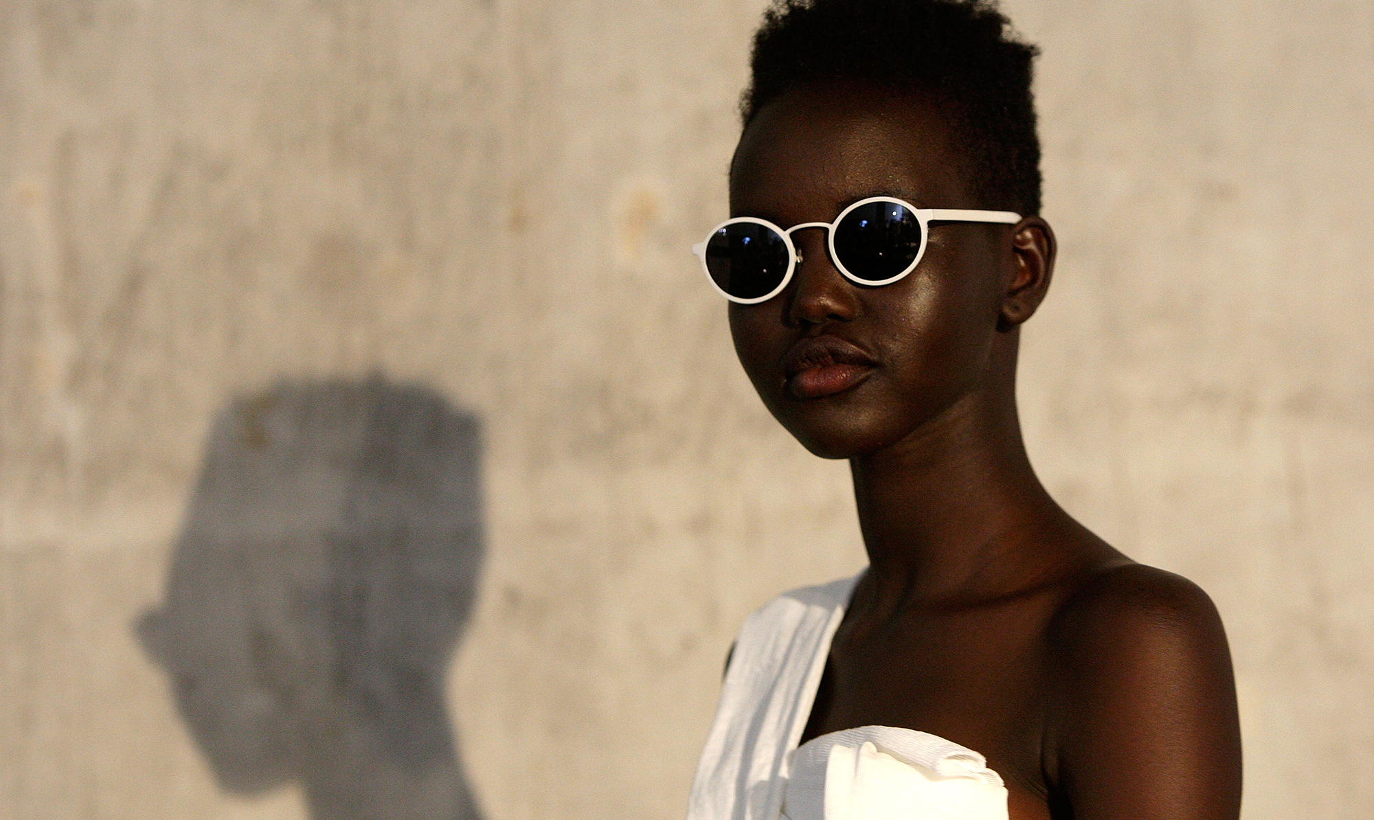Model Adut Akech har valgt en rund solbrillemodel med hvidt stel. Så smart! adut akech solbriller