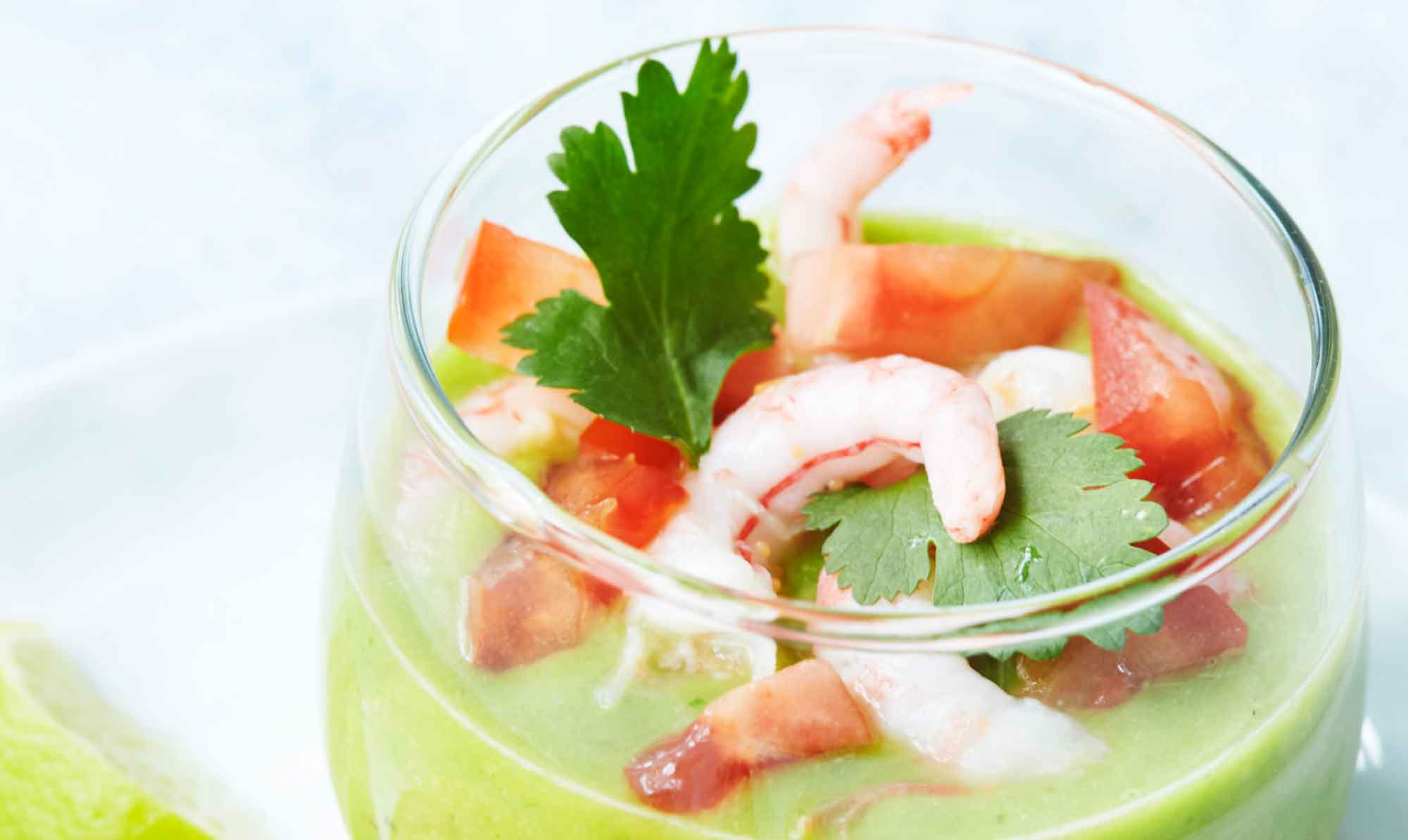 Kold avocadosuppe er en lækker forret eller let frokost til en varm dag. Her serveret med lækre pil-selv-rejer ved siden af. Kold avocadosuppe med rejer