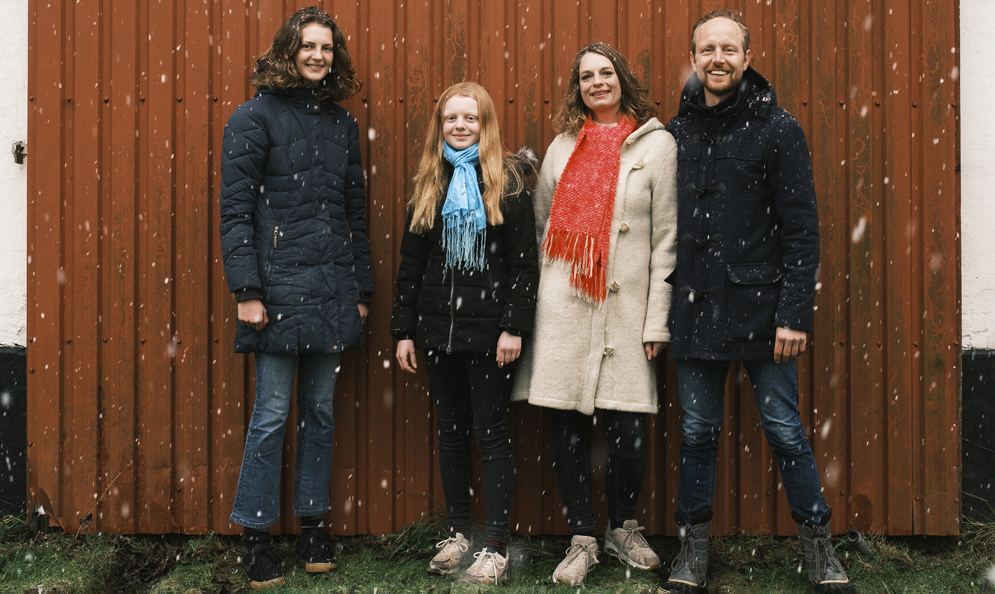 Charlotte Weitze, 46 år, er romanaktuel forfatter og klimablogger på 2030-planen.dk. Hun bor i Vallekilde med sin mand og to døtre. De fire medlemmer af Familien Weitze står foran en rød trævæg