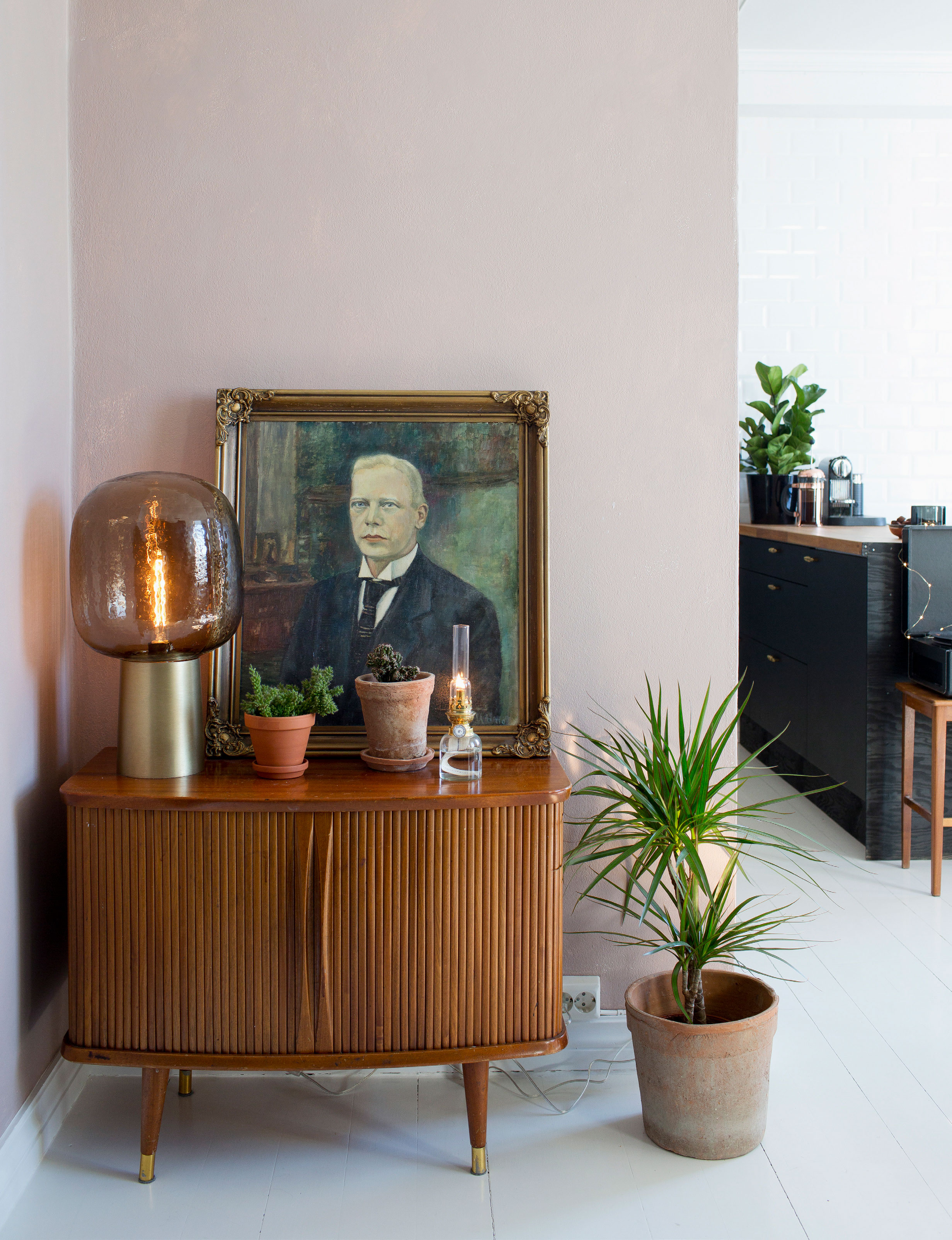 En enkelt væg er malet sart rosa for at bryde med de ellers hvide flader. Farven hedder Keramikk og er fra Jotun. Kommoden er et loppefund og lampen er fra House Doctor.