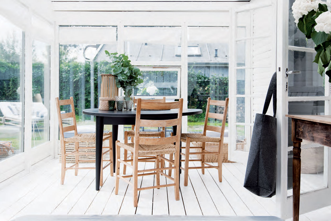 Havestuens spiseplads med kig til terrassen og den lille have. Spisebordet og stolene har Frederikke og Ole købt på Havnsø-havnens loppemarked.