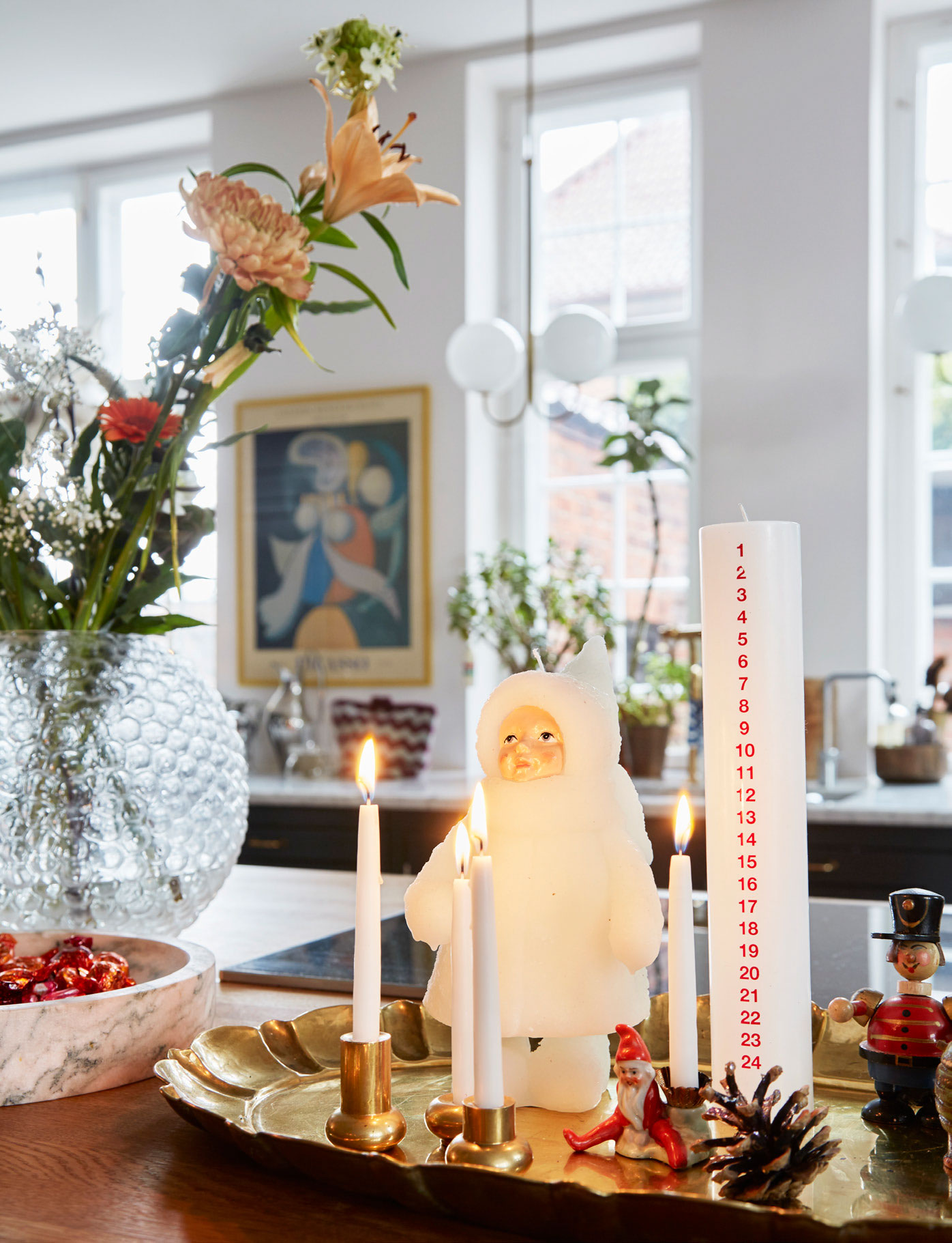 På en vintagebakke i messing står Saras kalenderlys fra Kunstindustrien i selskab med dukkelys fra Dora og blandet vintagepynt.