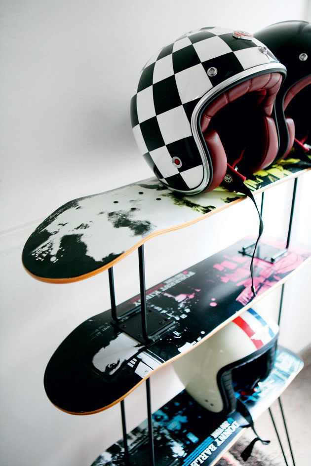 Reolen består af et metalmøbel og tre skateboards som hylder.