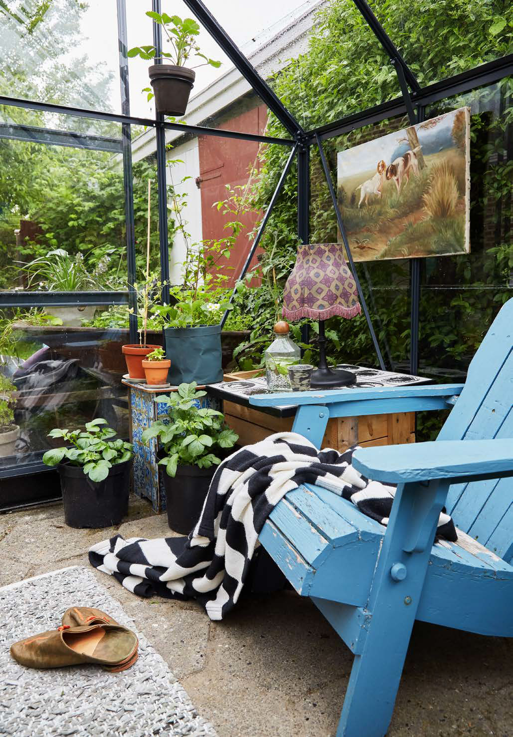 Trine har blik for små siddekroge, og her i drivhuset har hun fundet én af sine favoritpladser i haven, omgivet af planter fra gulv til loft.