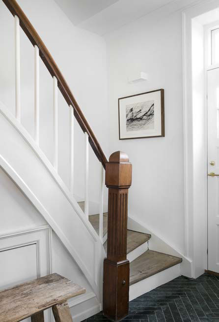 På trappen til første sal har Sara og Robert valgt at lade den elegante stolpe og gelænderet stå originalt. Gulvet i entreen er beklædt med fliser fra Bad og Fliser lagt i sildebensmønster.