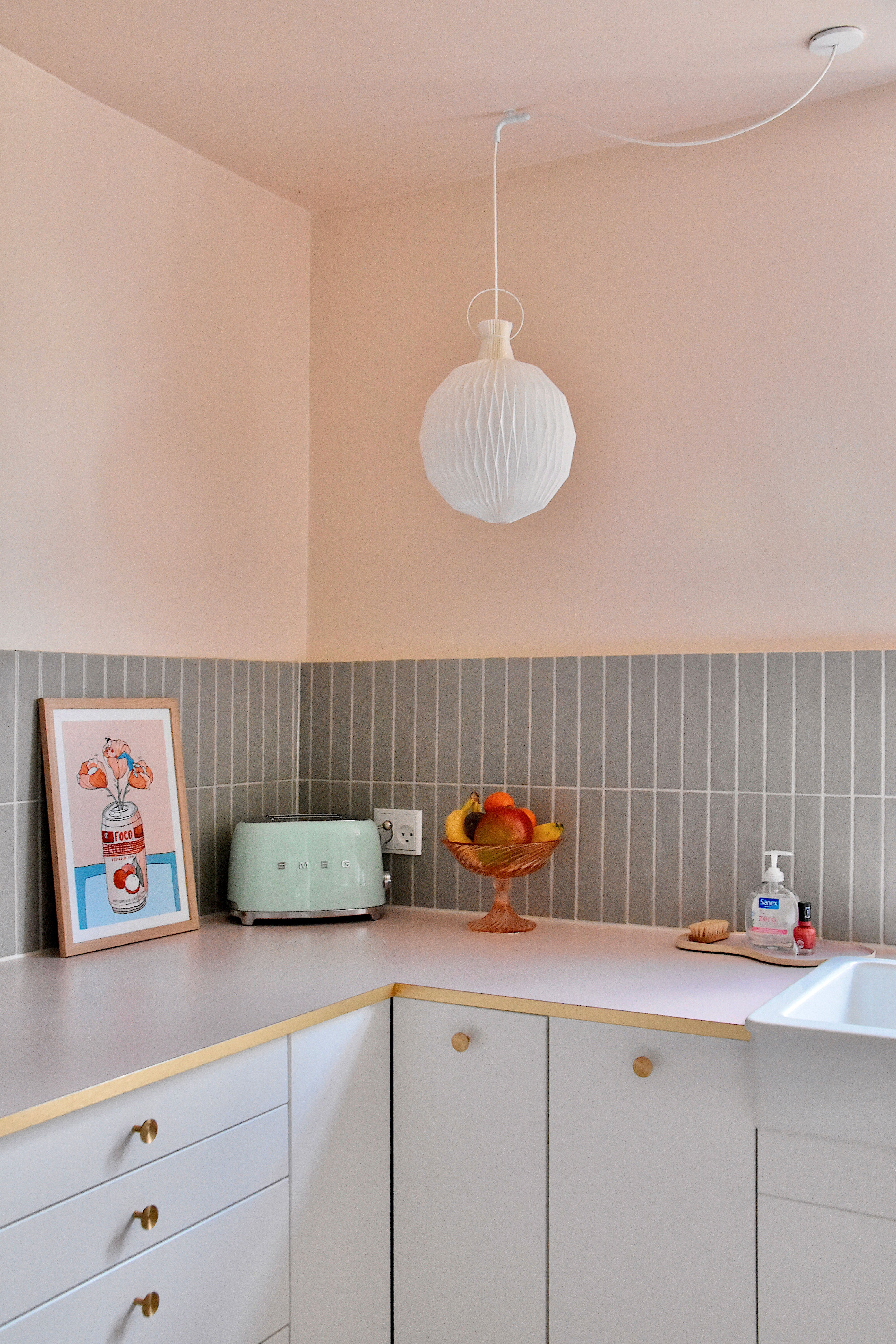 Bordpladen er Formica laminat i farven just rose og med laminat messingkant, fliser fra Mosaikhjørnet og lampe fra Le Klint.