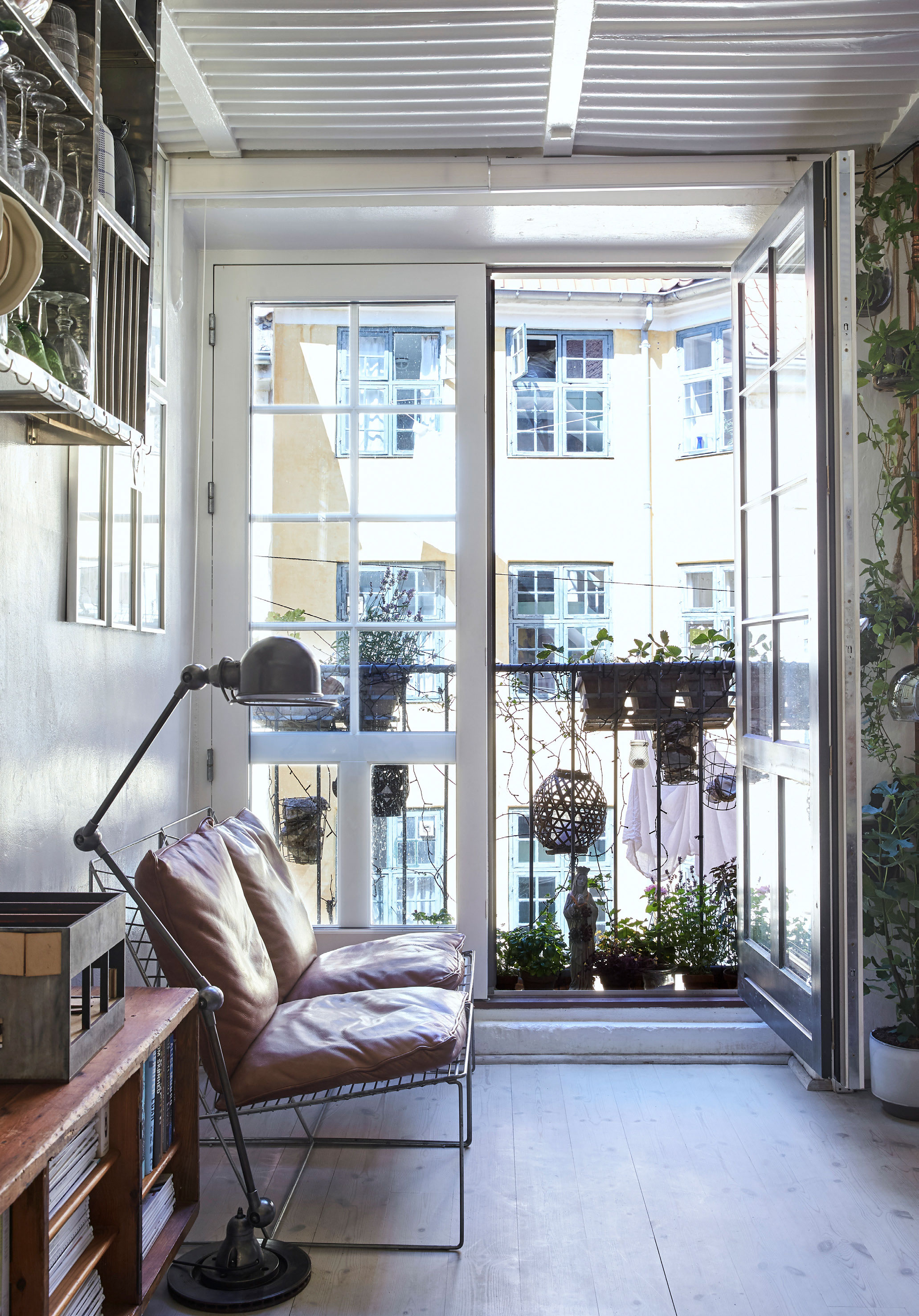 Laura elsker at sidde ved den store franske altan, når hun skal slappe af. Lampen er en vintage Jielde og stolene er prototyper fra møbelarkitekt Niels Jørgen Haugesen tilsat et. par læderhynder fundet på dba.dk