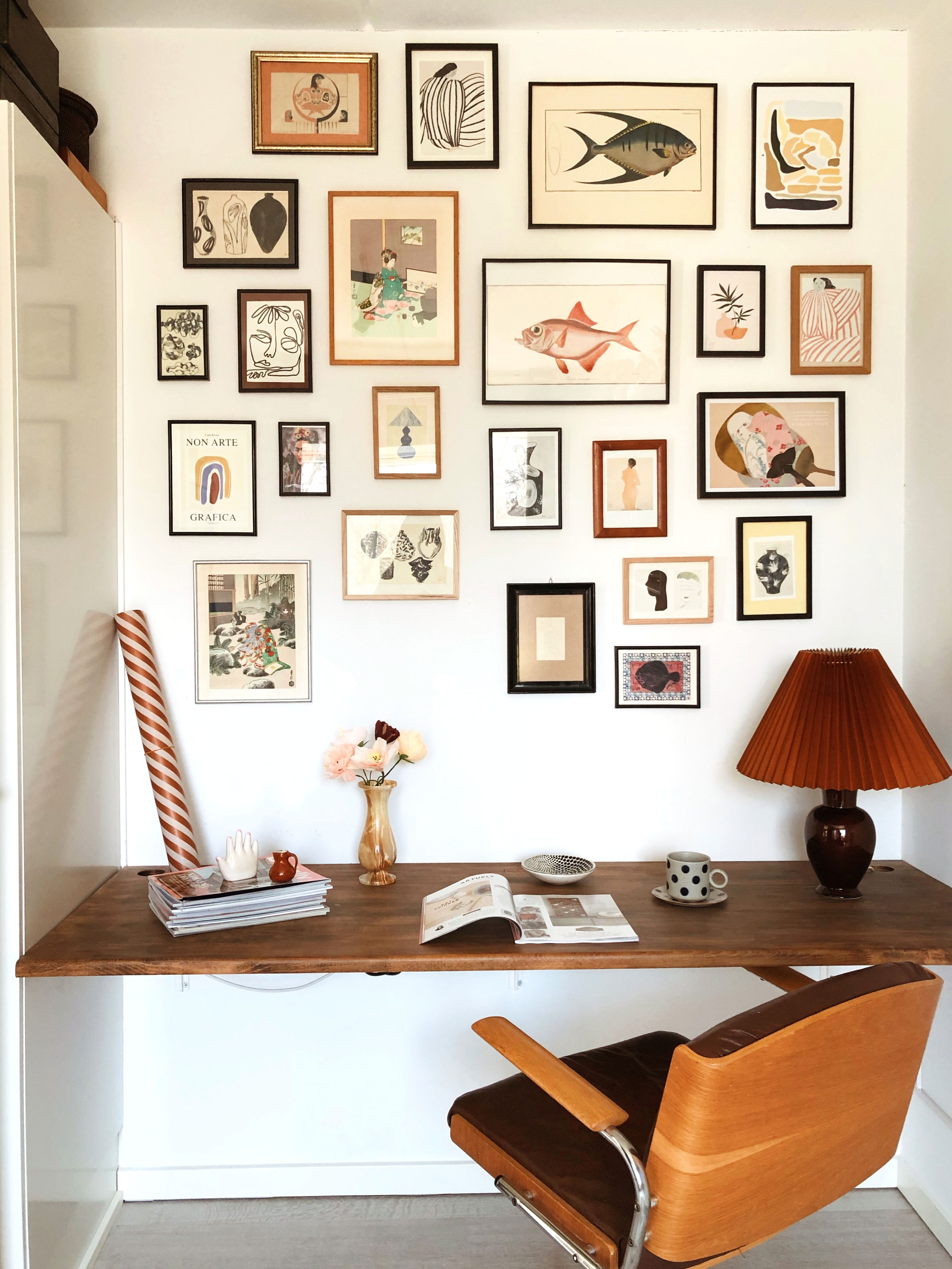På væggen hænger forskellige kunsttryk, som enten er købt på loppemarkeder, eller på diverse plakat-webshops. Kontorstol og lampe er fra Loppeladen Genbrug.