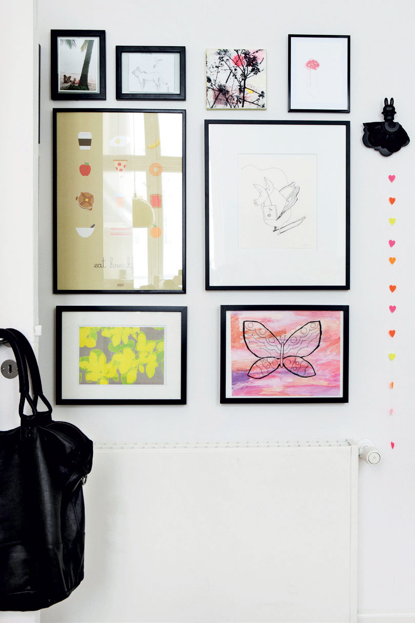 På en væg i køkkenet har Sidsel lavet et lille galleri af værker skabt af Lars Nørgård, print købt på etsy.com, egne værker og Nannas tegninger.