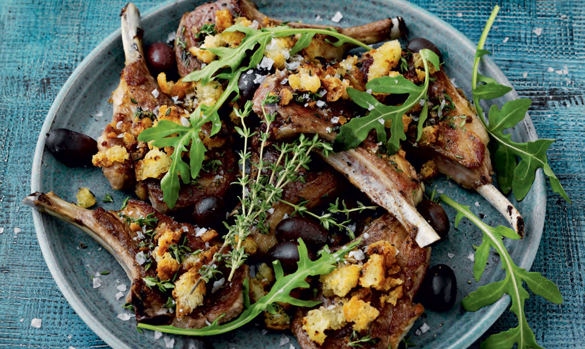 Lækre lammekoteletter. Lammekoteletter med sprød topping, oliven og rucola