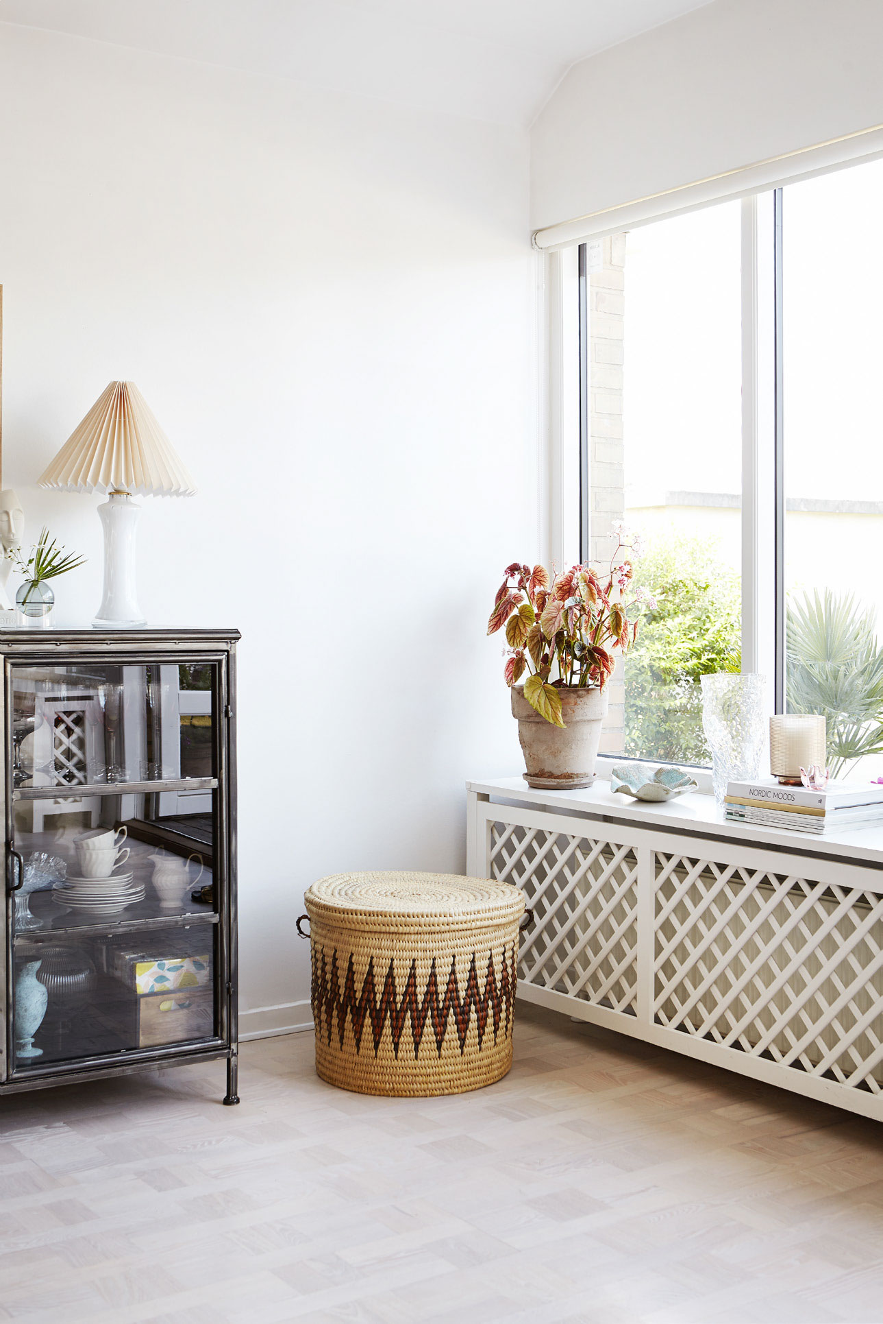 De store vinduespartier i stuen har fået selskab af smukke radiatorskjulere, som giver stuen et forfinet udtryk. Radiatorskjulerne har parret selv bygget. Den store fletkurv er et loppefund.