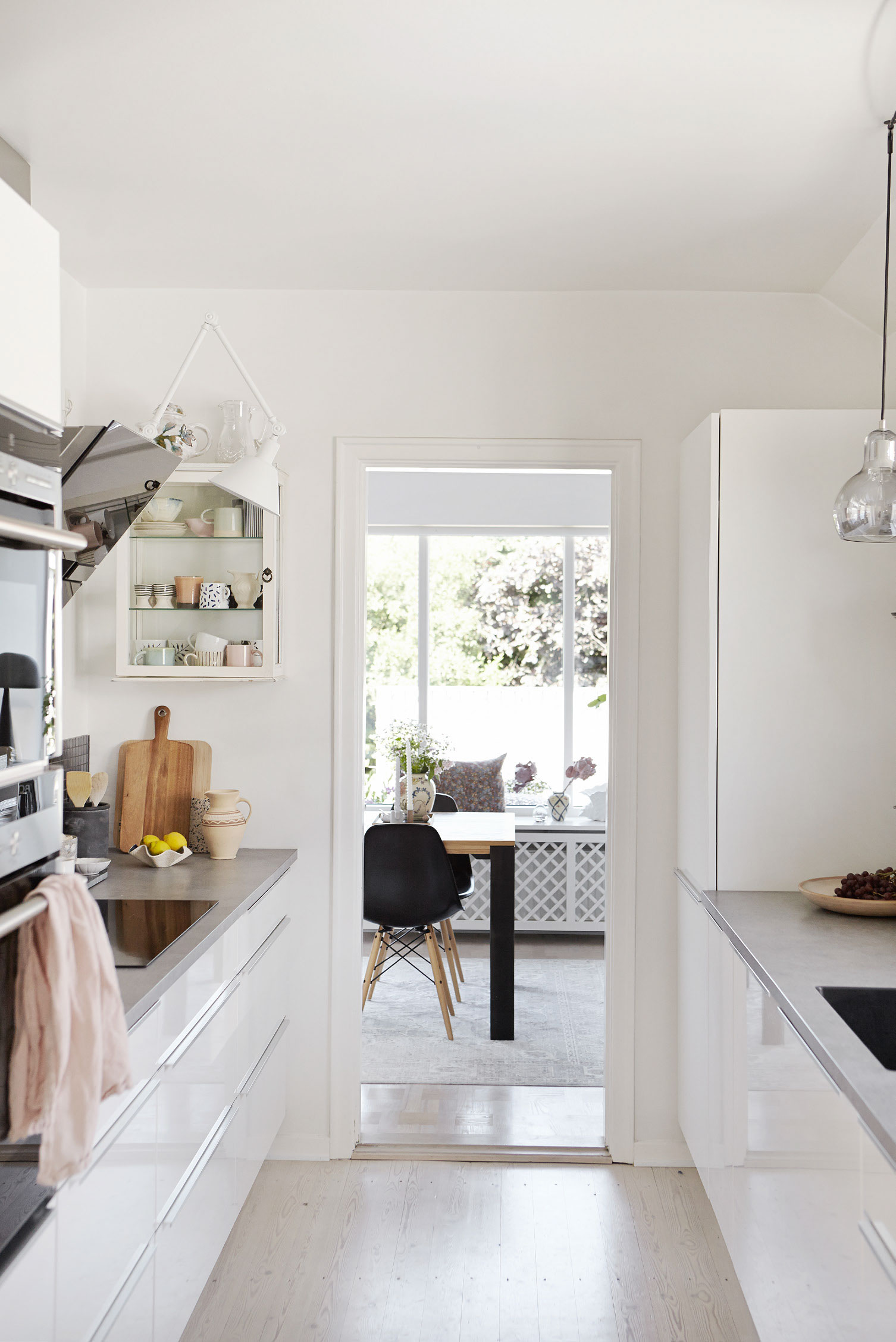 Tines mange keramikfund skaber hygge i det hvide køkken fra Vordingborg Køkkenet. Køkkenet er placeret i et gennemgangsrum med adgang til spisekrogen i stuen.