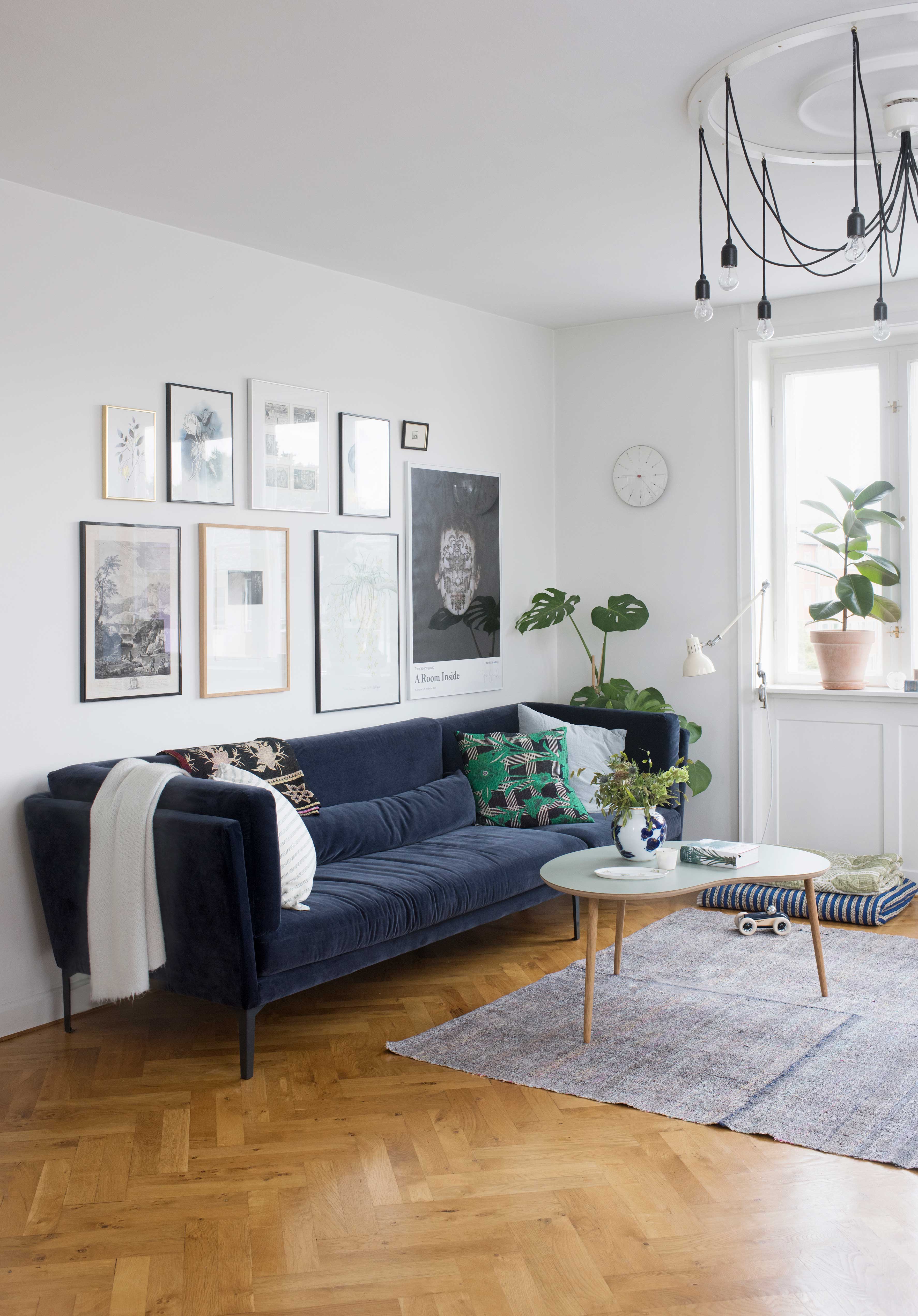 Blå sofa i velour og bønne-bord i stuen.