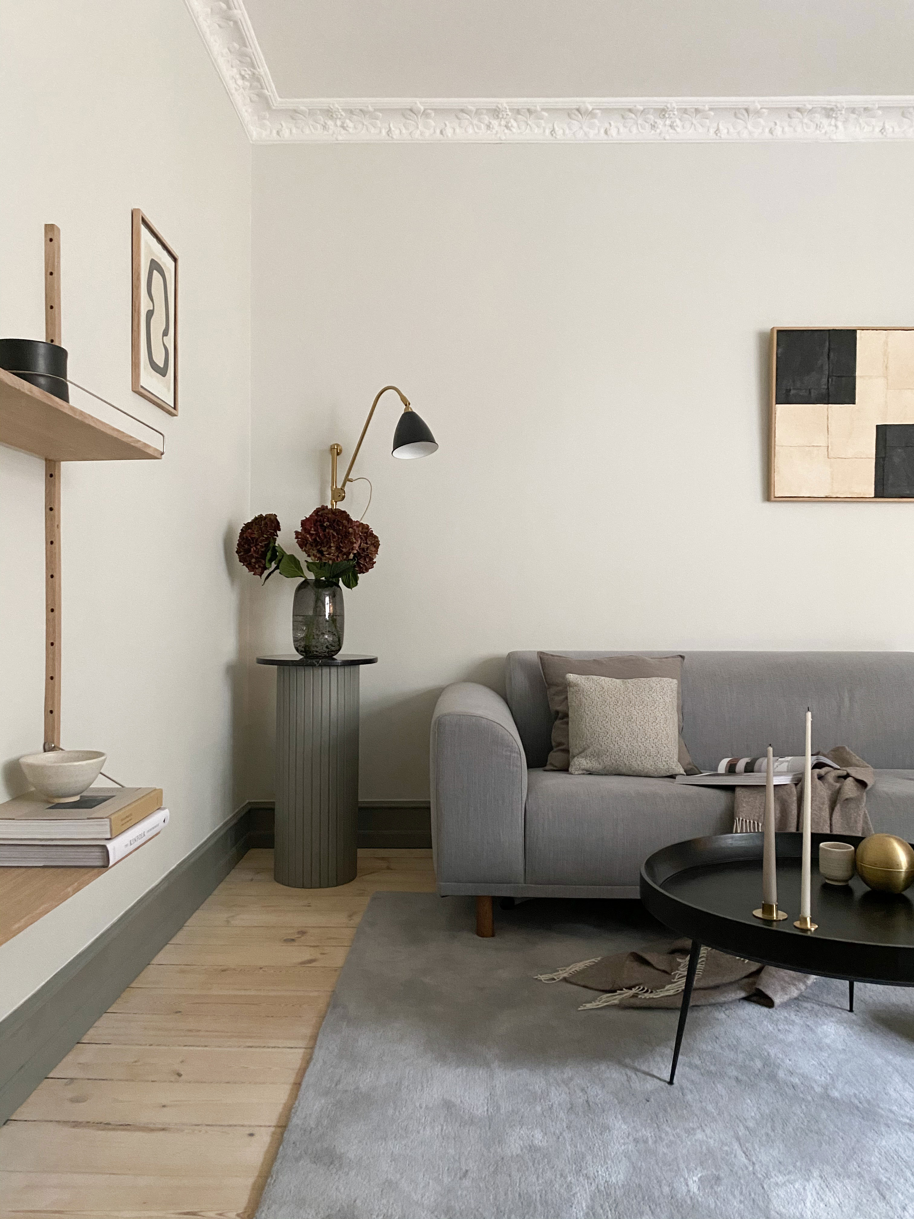 Sidebordet i stuen har Marie-Loiuse og Michael selv bygget. Tæppe fra HAY, lampe fra Gubi, hylde fra Frama, kunst fra Noa Noon Gammelgaard.