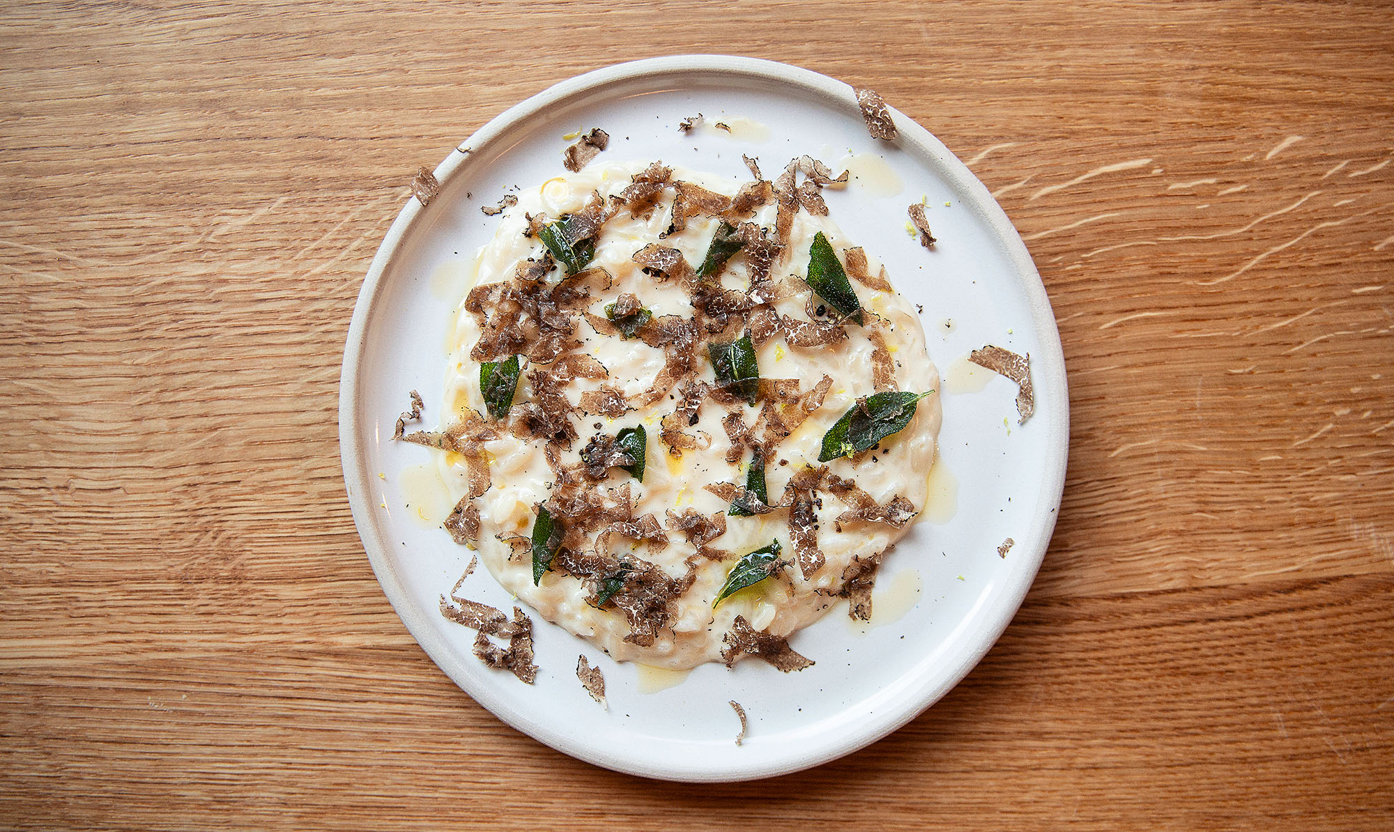 Risotto med rigelige mængder ost og smør og garniture i form af høvlspåner af sort trøffel og lidt smørstegt salvie. Polly
