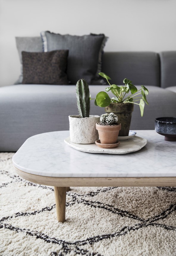 Marmor og træ skaber sanselighed i lejlighedens nye rammer. Sofabord fra &Tradition, sofa fra Hay og puder fra Christina Lundsteen, Hay og Stricaholic. Keramik fra Studio Arhoj og Von der Erde.